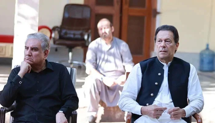 This photograph released on October 24, 2023, shows PTI founder Imran Khan (R) and Vice Chairman Shah Mahmood Qureshi while listening to party members. — Facebook/Imran Khan