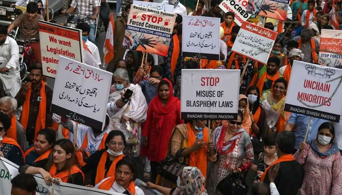 Activists hold placards as they march to mark National Minorities Day in Lahore, August 11, 2021. — AFP