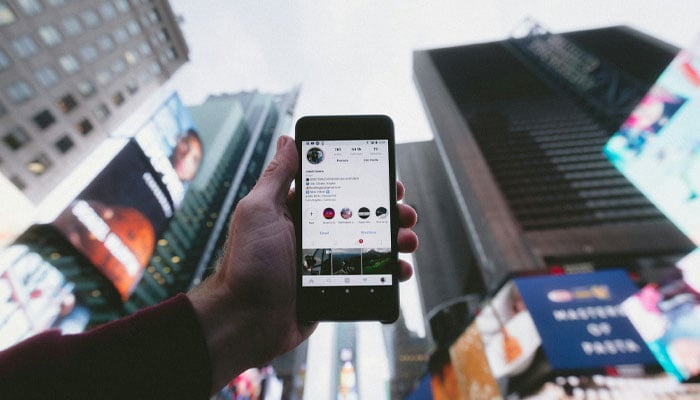 Representational image of a person holding a phone displaying the Instagram app. — Unsplash