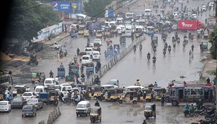 People travelling on a road during rain in Karachi on August 2, 2024. —Online