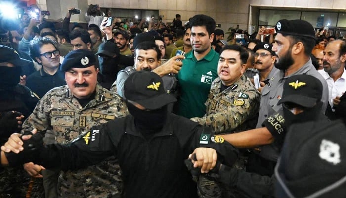 Security officials escort Pakistan’s javelin gold medalist at the Paris Olympics 2024 Arshad Nadeem (C) upon his arrival at the Allama Iqbal International Airport in Lahore on August 11, 2024. — AFP