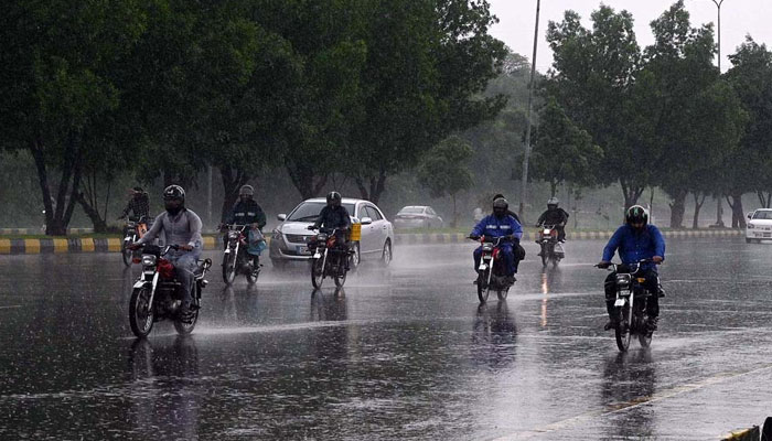 Vehicles and bikers make their way through heavy rain at Zero Point in Islamabad on August 15, 2024. APP