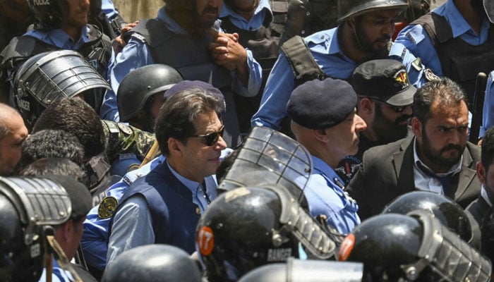 Policemen escort Pakistans former Prime Minister Imran Khan (C) as he arrives at the high court in Islamabad on May 12, 2023. — AFP