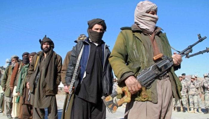 Afghan Taliban standing in a line with their weapons. — AFP/File