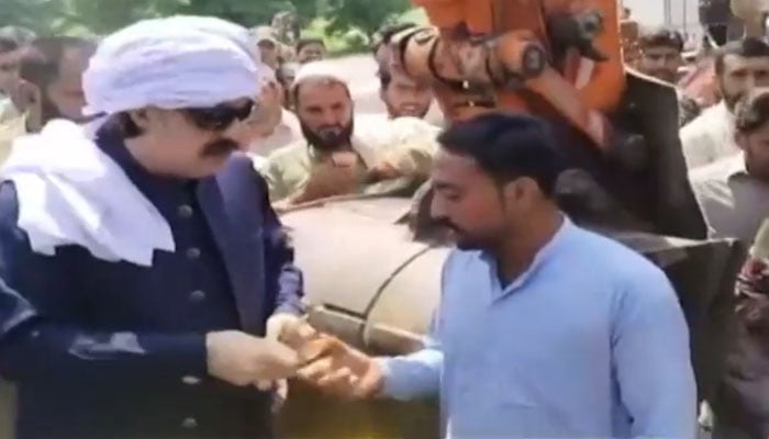 Khyber Pakhtunkhwa Chief Minister Ali Amin Gandapur distributes cash among party workers on August 22, 2024. — Screengrab/Geo News