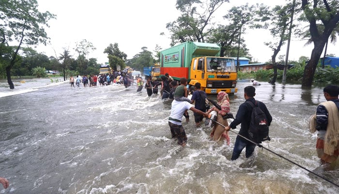 People wade through flood waters in Feni, Bangladesh on August 22, 2024. — AFP