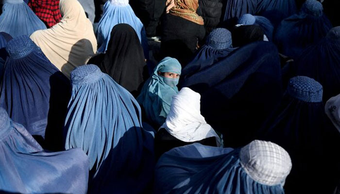 A girl sits in front of a bakery in the crowd with Afghan women waiting to receive bread in Kabul, Afghanistan, January 31, 2022. — Reuters