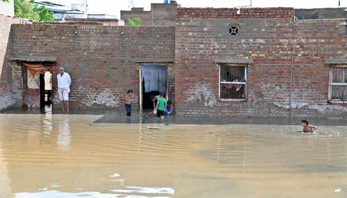 A view of stagnant rainwater accumulated in front of houses near the Government Boys Degree College after heavy rain in Larkana on August 19, 2024. —  APP