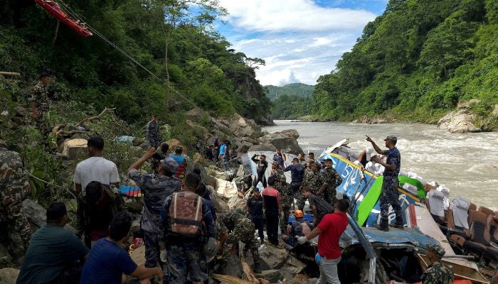 Security force personnel rescue an injured passenger after a bus carrying Indian passengers traveling to Kathmandu from Pokhara plunged into a river in Tanahun District, Gandaki Province, Nepal August 23, 2024.