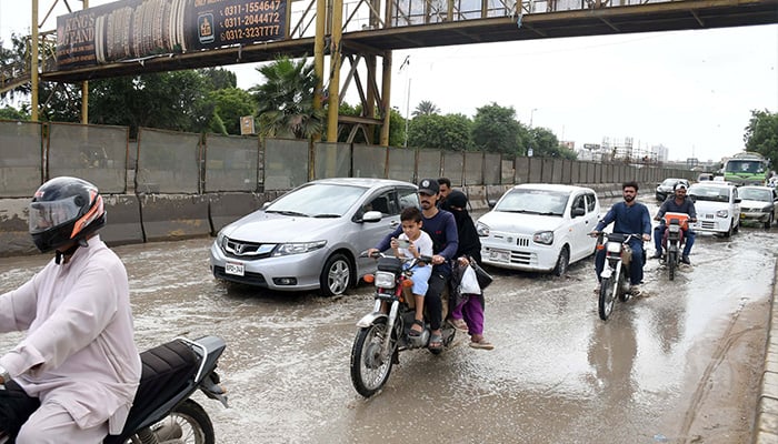 Commuters are facing difficulties due to accumulated rainwater at University Road, Karachi. — Online