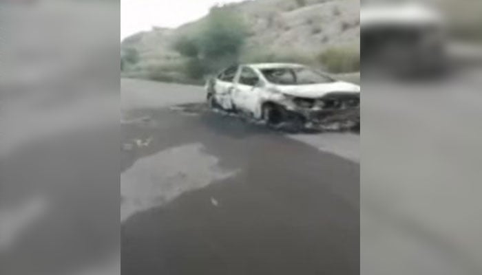 A burnt vehicle can be seen at the site of the incident where armed men offloaded and gunned down around two dozen people in Balochistans Musakhel on August 26, 2024. — Screengrab via Geo News