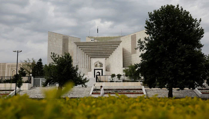 Policemen sit beside Pakistans Supreme Court building during a hearing in Islamabad on April 6, 2022. — AFP