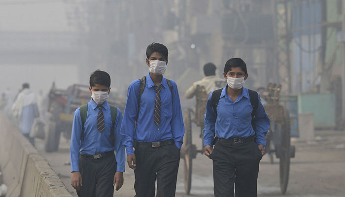 A representational image showing students in face masks due to air pollution, smog. — AFP/File