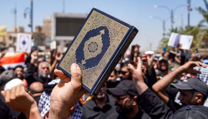 A man holding the Holy Book of Islam, Quran during a demonstration. — AFP/File