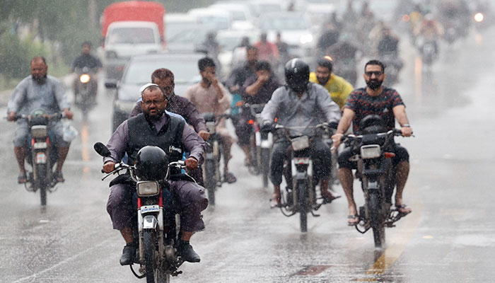 Commuters ride on motorcycles during a rain in Karachi, Pakistan August 2, 2024. — Reuters