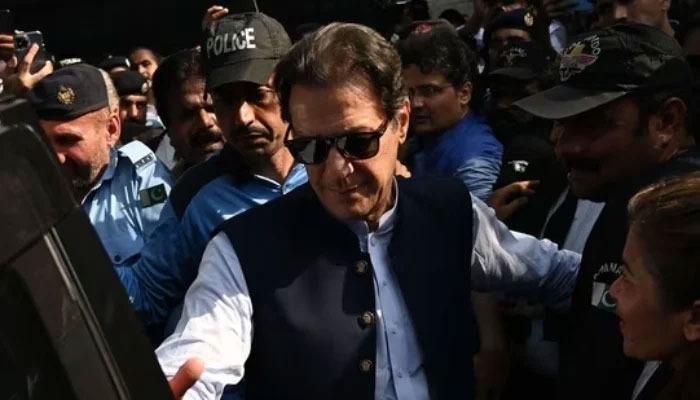 Security personnel escort PTI funder and former prime minister Imran Khan as he appears at a court in Islamabad. — AFP/File