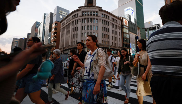 People cross the street at Ginza shopping district in Tokyo, Japan on August 11, 2024. — Reuters