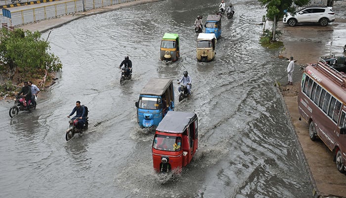 Traffic drive through a flooded road caused by heavy monsoon rainfall in Karachi on August 31, 2024. — Online