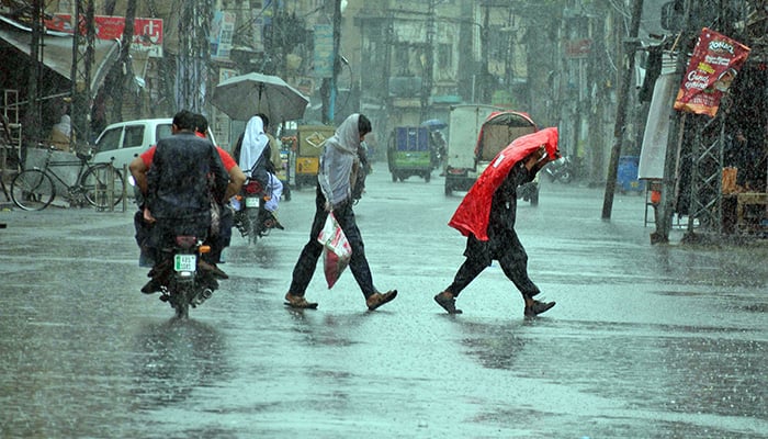 People on their way at Jamia Masjid Road during heavy monsoon rain in Rawalpindi on August 30, 2024. — Online