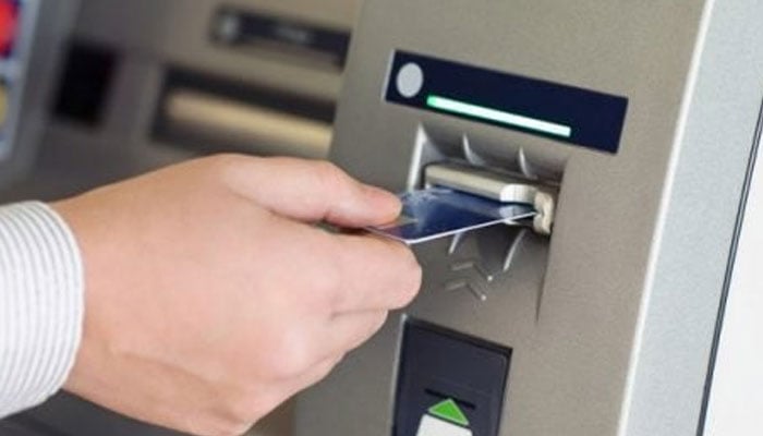 A person inserting a card in an Automated Teller Machine (ATM). — Reuters/File