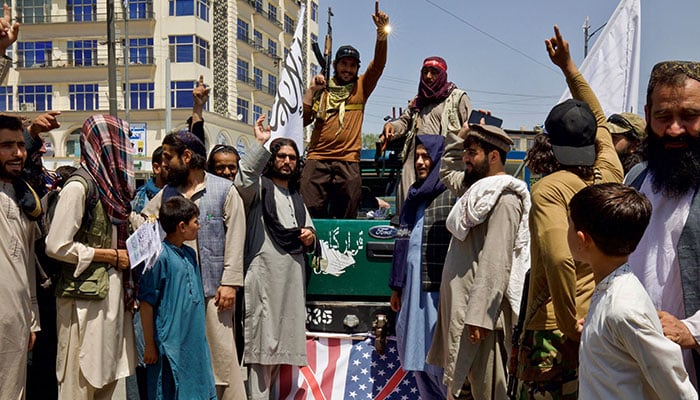 Members and supporters of the Taliban stand on a US flag as they hold a rally to mark the third anniversary of the fall of Kabul, in Kabul, Afghanistan, August 14, 2024. — Reuters