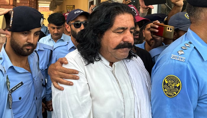 Police officials present arrested politician Ali Wazir (centre) before a court in Islamabad on August 20, 2023. — AFP/File