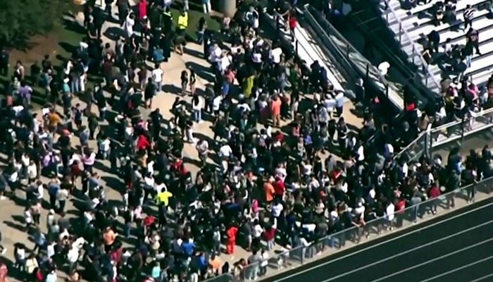 Students and staff gather next to the football field after law enforcement officers responded to a fatal shooting at Apalachee High School in a still image from aerial video in Winder, Georgia, US September 4, 2024. — Reuters