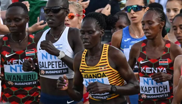 Ugandas Rebecca Cheptegei (centre, yellow shirt) is seen among her peers at a marathon. — AFP/File