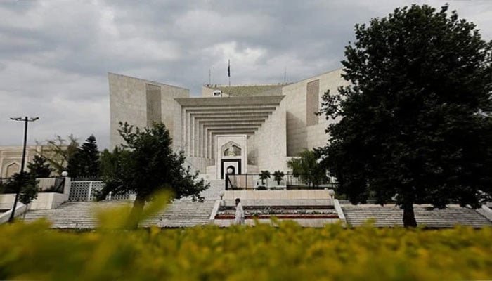 A man uses his mobile phone as he walks past the Supreme Court of Pakistan building in Islamabad, Pakistan May 13, 2023. — AFP