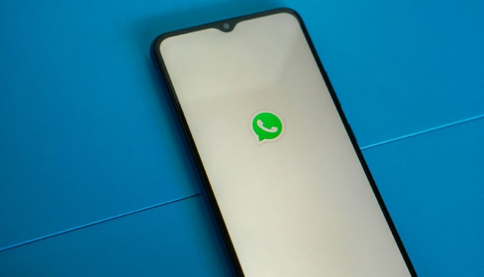 A representational image of the WhatsApp logo displayed on a phone screen. — Unsplash