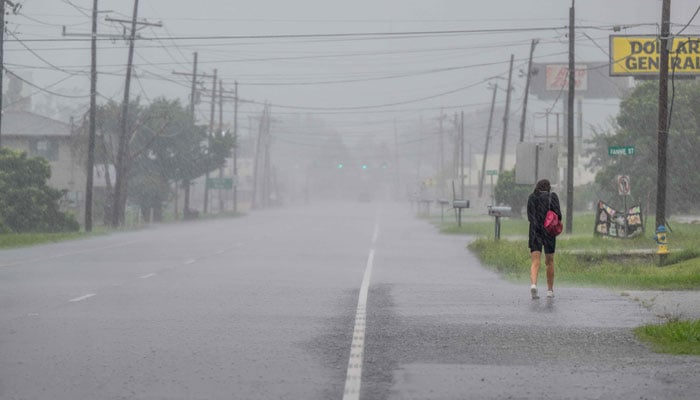 A person walks through a downpour as Hurricane Francine hits the area on September 11, 2024 in Houma, Louisiana. — AFP