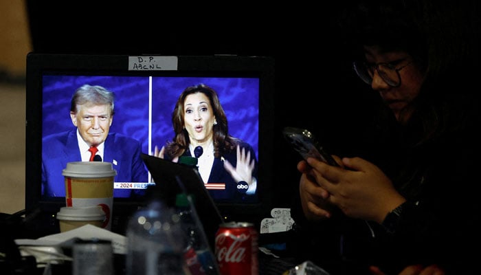 A member of the media uses phone as a screen displays the presidential debate, as Republican presidential nominee, former US President Donald Trump and Democratic presidential nominee, US Vice President Kamala Harris attend a presidential debate hosted by ABC in Philadelphia, Pennsylvania, US, September 10, 2024. — Reuters