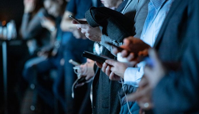 A representational image of a several people using their phones. — Unsplash