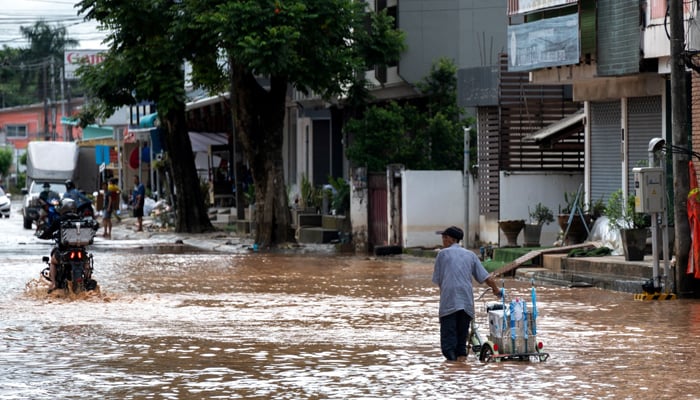 People wade through floods following the impact of Typhoon Yagi, in Chiang Rai in the northern province of Thailand on September 13, 2024. — Reuters