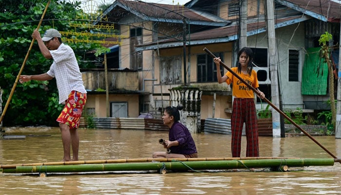 Flood-affected residents ride a bamboo raft in Taungoo, Myanmars Bago region on September 14, 2024, following heavy rains in the aftermath of Typhoon Yagi. — AFP