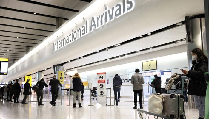 Travellers stand at Terminal 2 of Heathrow Airport in London, Britain February 14, 2021. — Reuters