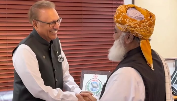 Former president and PTI leader Arif Alvi (left) shakes hands with JUI-F Chief Maulana Fazlur Rehman ahead of the meeting in Islamabad on September 17, 2024. — Screengrab via Geo News