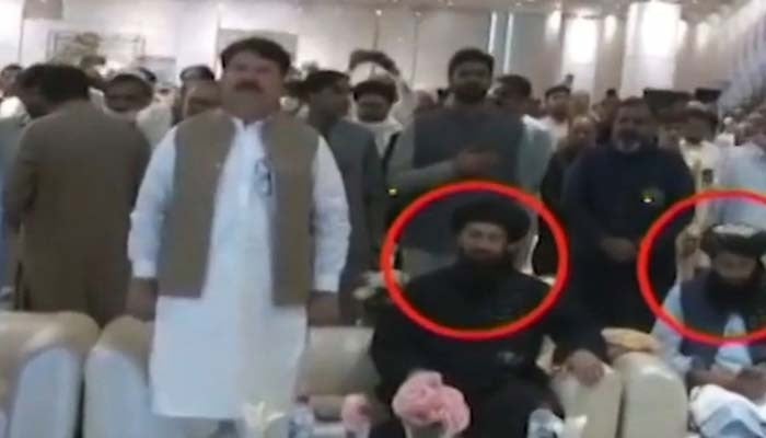 Afghan Acting Consul General Peshawar Hafiz Mohibullah Shakir (second from right) is seen sitting during Pakistani national anthem at a conference in Peshawar. — Screengrab via Geo News