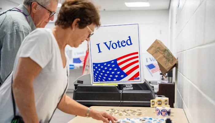 A woman picks out a sticker after voting on the first day of Virginias in-person early voting at Long Bridge Park Aquatics and Fitness Centre on September 20, 2024 in Arlington, Virginia. — AFP