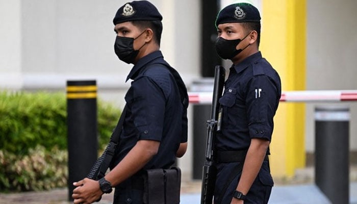 Members of the Royal Malaysia Police guard the entrance toward the National Palace in Kuala Lumpur on November 21, 2022. — AFP