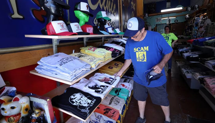 Store owner Bill Wyatt places screen printed t-shirts with an image depicting the mugshot of former US President Donald Trump at the Y-Que printing store in Los Angeles, California, US on August 26. — Reuters