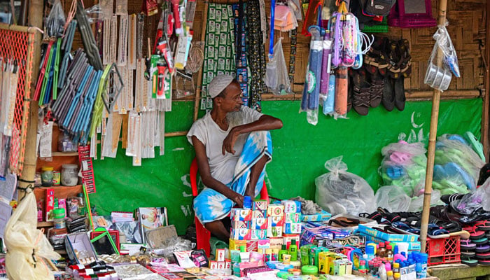 A Rohingya refugee shopkeeper waits for customers in a market at a refugee camp in Ukhia on September 12, 2024. — AFP