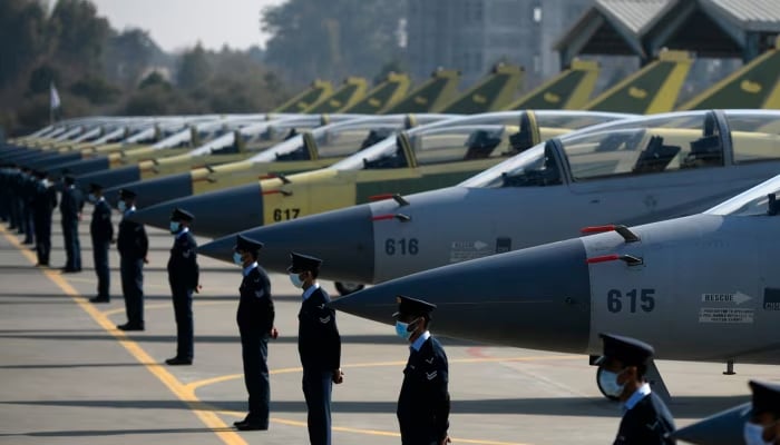 Pakistan Air Force (PAF) personnel stand guard in front of 14 JF-17B multirole aircraft at a ceremony in 2020. — AFP