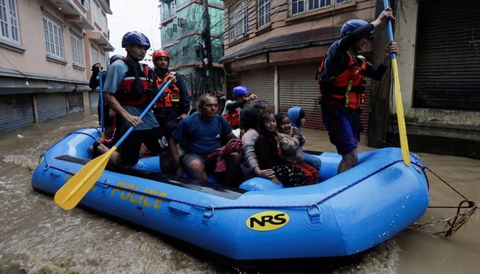 Security force members use an inflatable raft to bring residents to safety from a flooded area near the bank of the overflowing Bagmati River following heavy rains, in Kathmandu, Nepal on September 28, 2024. — Reuters