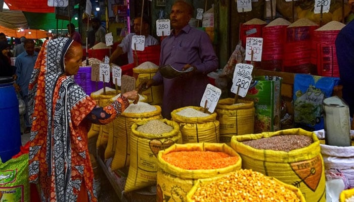 Seorang pelanggan membeli beras di toko grosir di Karachi pada 8 Juni 2023.— AFP