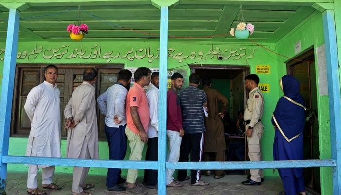 People wait in a line to vote outside a polling station, during the third and final phase of the assembly election, in north Kashmirs Bandipora district October 1, 2024.