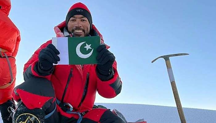 Sirbaz Khan holds Pakistan flag as he gestures for a photograph. — APP/File