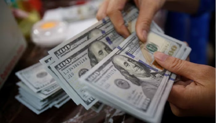 An employee of a bank counts US dollar notes at a branch in Hanoi, Vietnam May 16, 2016.— Reuters