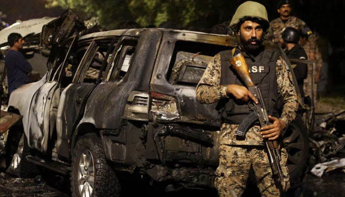 A member of the Airport Security Force ASF stands guard near the wreckage of vehicles after an explosion near Jinnah International Airport in Karachi, Pakistan October 6, 2024. — Reuters