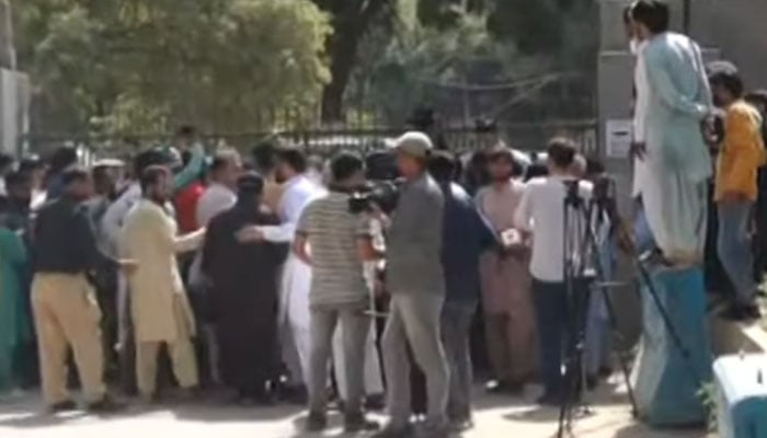 Workers of political parties are seen gathered outside the ECP office in Saddar on October 11, 2024. — Screengrab via YouTube/Geo News Live